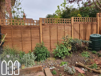 Waney fencing with wooden posts and a box trellis